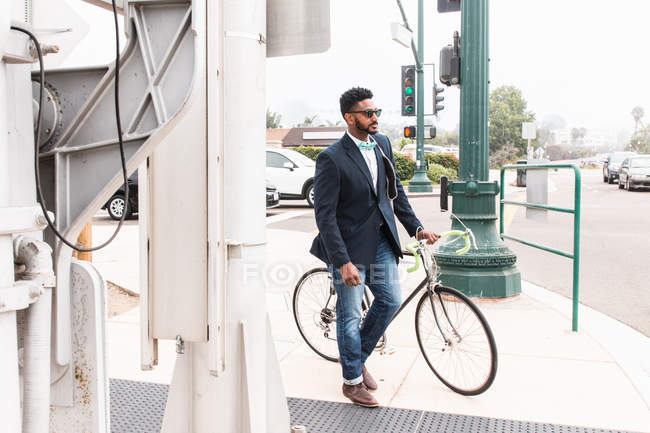 Jeune homme poussant le vélo sur le quai de la gare — Photo de stock
