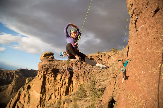 Bergsteigerin schwingt sich am Seil aus dem Smith Rock State Park, Oregon, USA — Stockfoto