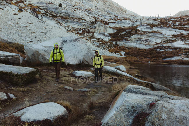 Dois caminhantes masculinos caminhando por lago, Mineral King, Sequoia National Park, Califórnia, EUA — Fotografia de Stock