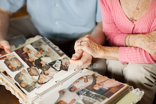 Coppia anziana con a album di famiglia — Foto stock