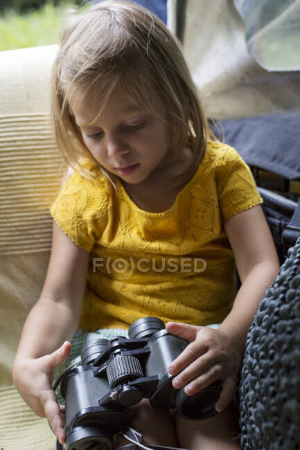 Menina segurando binóculos — Fotografia de Stock