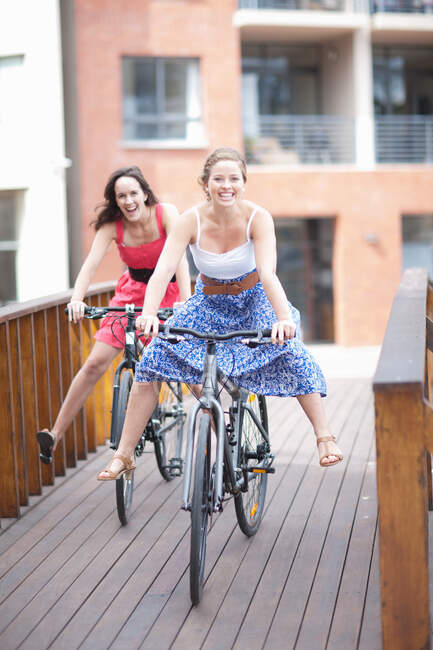 Две молодые женщины на велосипеде — стоковое фото