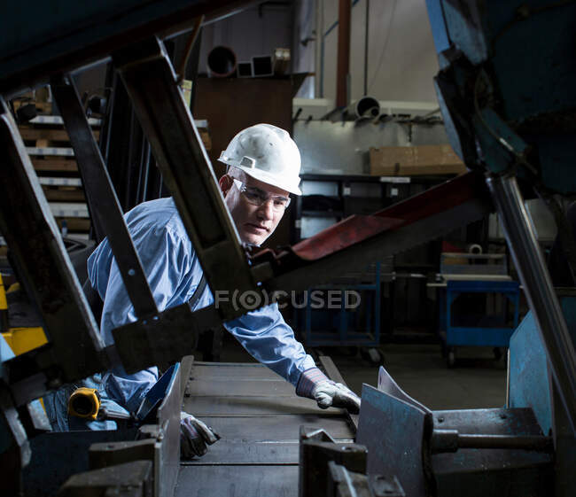 Worker using machinery in metal plant — Stock Photo