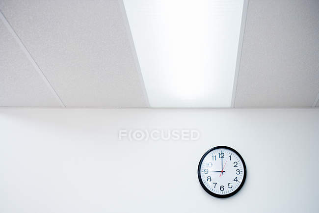 Часы на белой стене офиса — стоковое фото