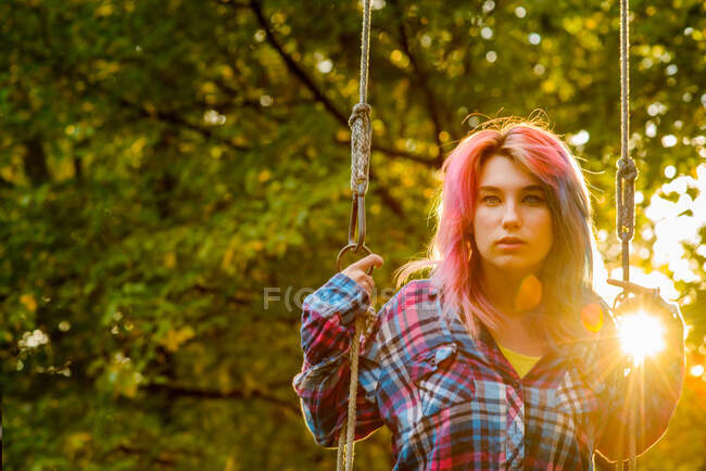 Ritratto di adolescente con capelli multicolori, su altalena da giardino — Foto stock