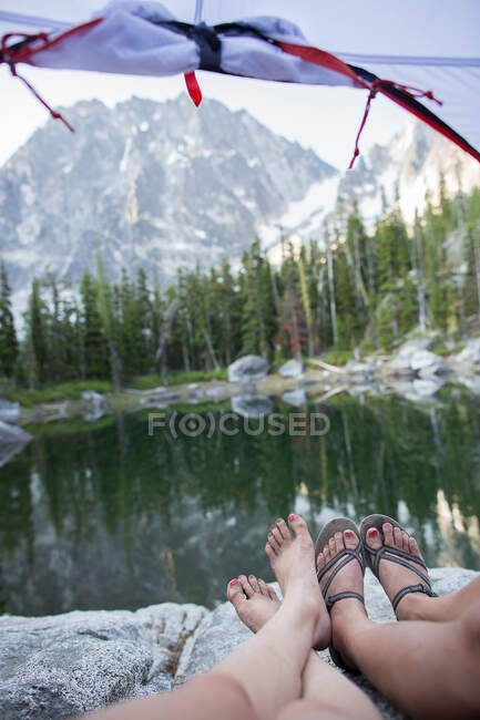 Two young women relaxing in tent beside lake, The Enchantments, Alpine Lakes Wilderness, Washington, USA — Stock Photo