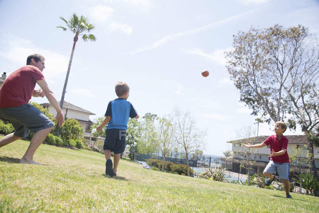 Mann und zwei Söhne praktizieren American Football im Park — Stockfoto