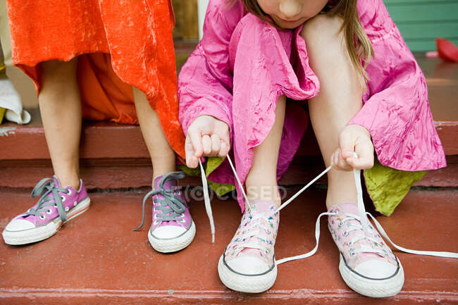 Due ragazze, una legata al lacci delle scarpe — Foto stock