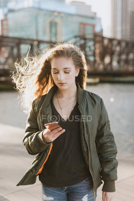 Mujer joven usando teléfono móvil en la ciudad, Boston, Massachusetts, EE.UU. - foto de stock