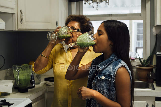 Grandmother and granddaughter drinking smoothies — Stock Photo