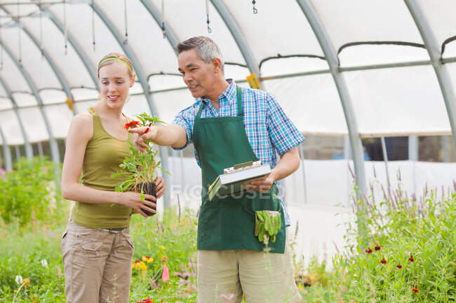 Maturo assistente di vendita e di metà donna adulta in giardino centro — Foto stock