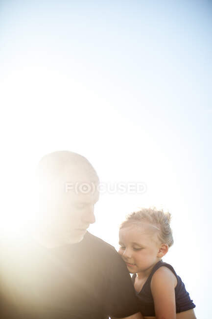 Pai e filho sentados ao ar livre, expressões pensativas — Fotografia de Stock