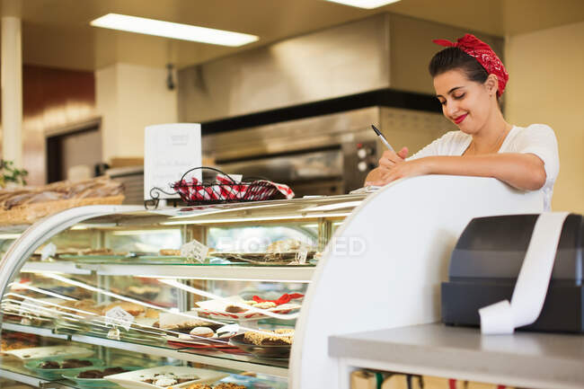 Молода жінка працює на лічильнику хлібобулочних виробів — стокове фото