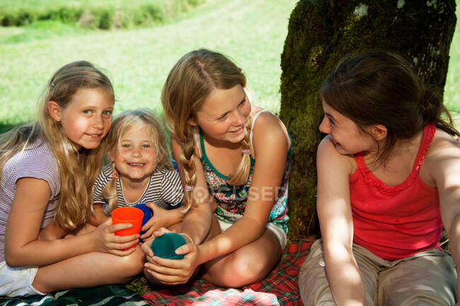 Четверо дітей сидять на пікніку. — стокове фото