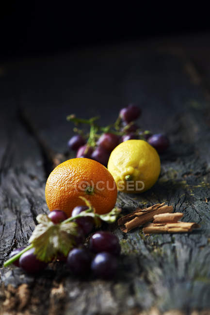 Fruta y canela en la superficie de madera vieja - foto de stock