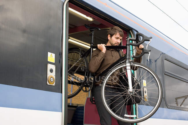Чоловік з велосипедом на поїзді — стокове фото