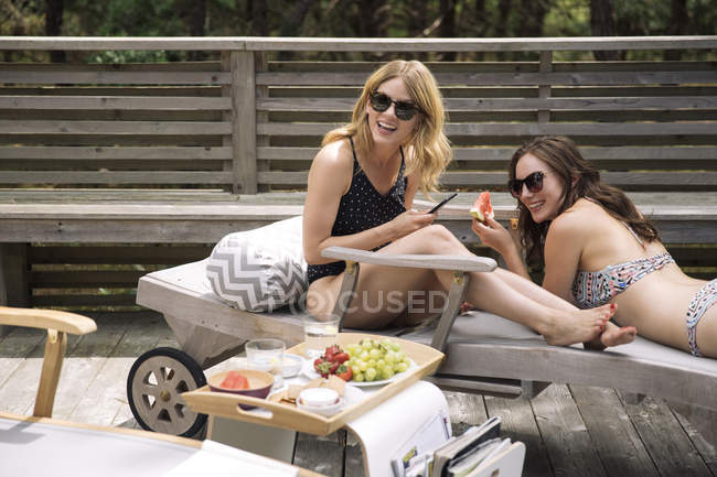 Frauen entspannen sich und essen Früchte auf Liegestühlen, amagansett, New York, USA — Stockfoto