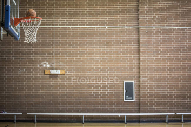 Baloncesto a punto de caer por la red de baloncesto - foto de stock