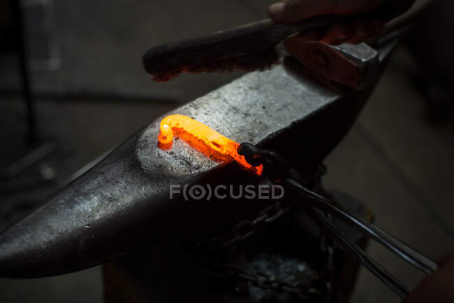 Red hot metal rod on metal workshop anvil — Stock Photo