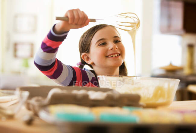 Девушка смешивает тесто для торта в миске — стоковое фото