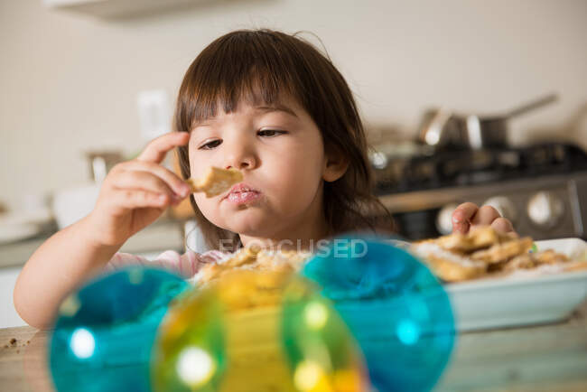 Девочка ест рождественское печенье — стоковое фото