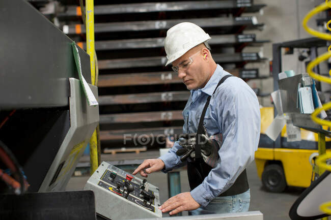 Worker at control panel in metal plant — Stock Photo