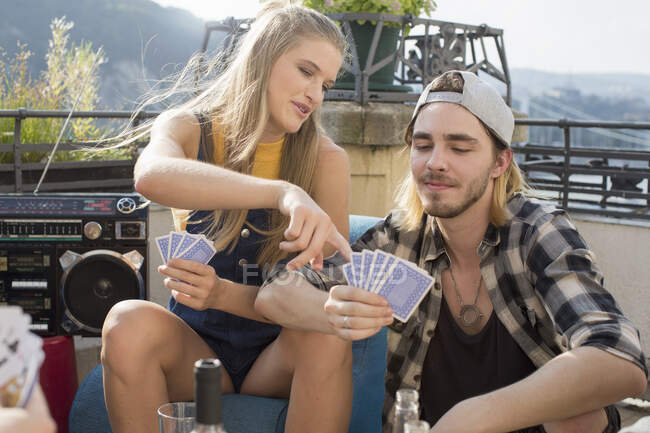 Jovem casal jogar jogo de cartas na festa terraço telhado, Budapeste, Hungria — Fotografia de Stock