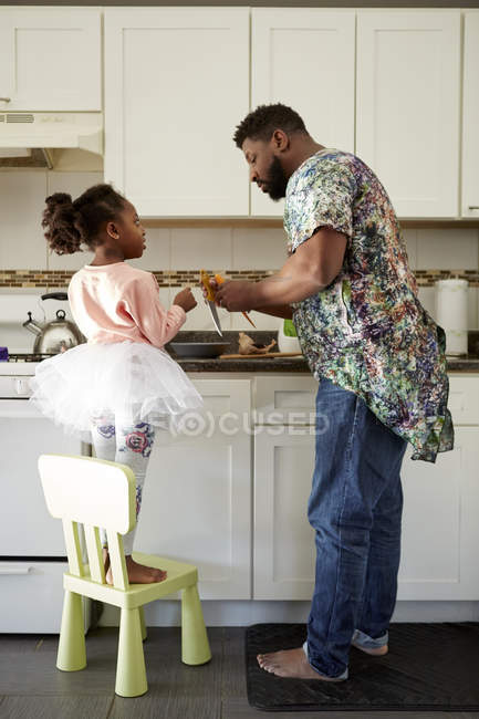 Uomo maturo insegnare figlia su coltelli da cucina in cucina — Foto stock
