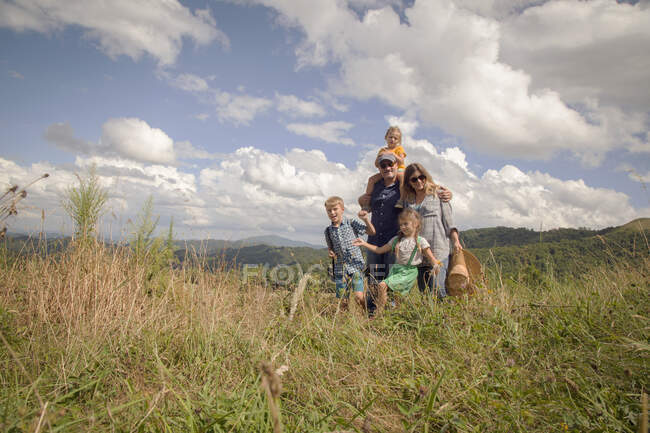 Família caminhando juntos através do campo — Fotografia de Stock