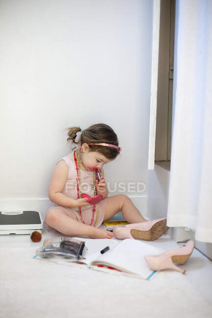 Girl dressing up, playing with lipstick — Stock Photo