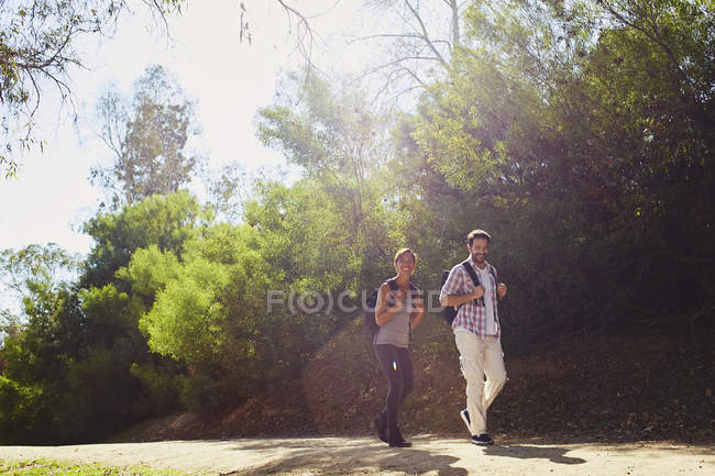 Couple randonnée, promenade le long de la route rurale éclairée par le soleil — Photo de stock