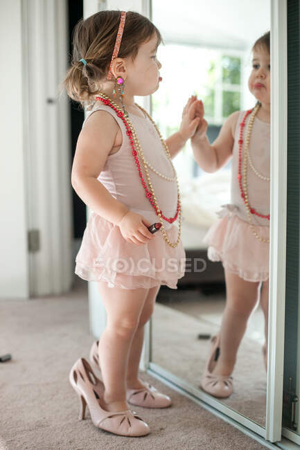 Girl dressing up, playing with lipstick — Stock Photo