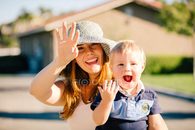 Portrait of mother and young son, waving — Stock Photo