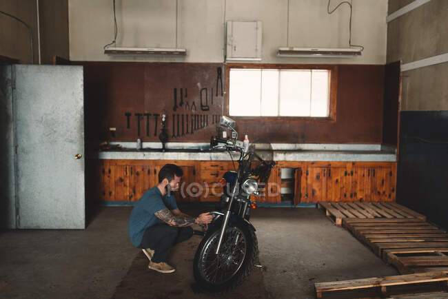 Mann repariert Fahrrad in Werkstatt — Stockfoto