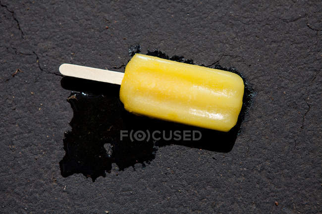 Derretimiento de hielo lolly en el suelo - foto de stock