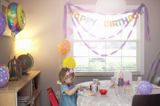 Retrato de menina loira sentada na mesa de festa de aniversário — Fotografia de Stock