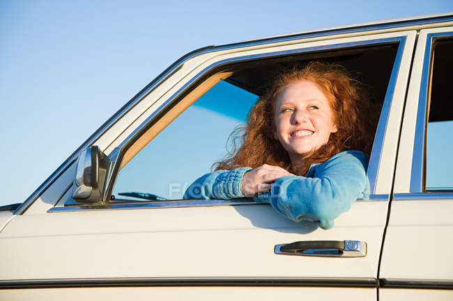 Молодая женщина высунулась из окна машины — стоковое фото