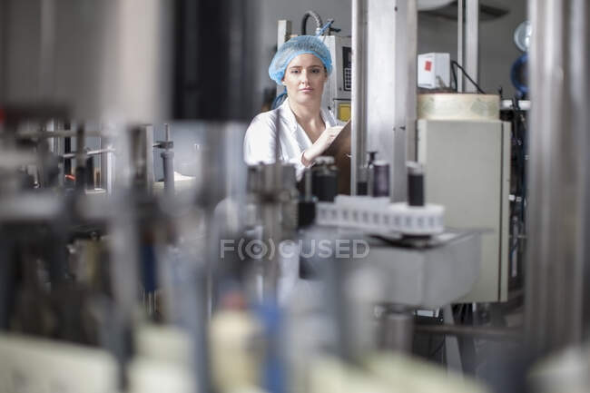 Cape Town, South Africa, female worker in overalls and safety head net writing down on file stock itenary — Stock Photo