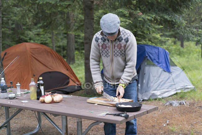 Hombre maduro preparando comida en el camping, Washington, EE.UU. - foto de stock