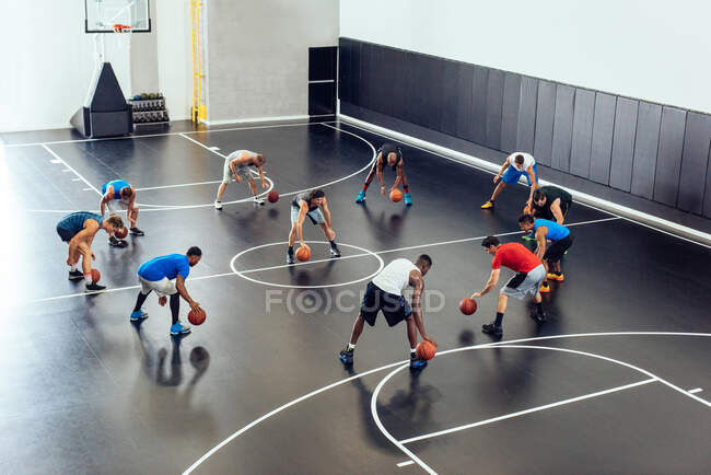 Male trainer and basketball team practicing on court — Stock Photo