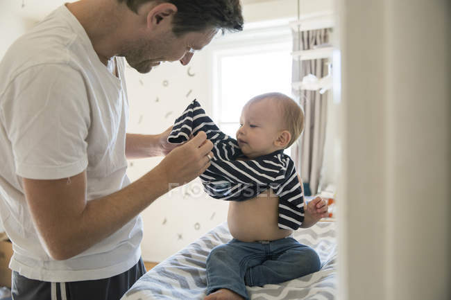 Pai vestir filho em casa — Fotografia de Stock