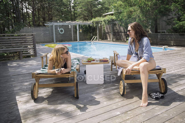 Mujeres relajándose y charlando en tumbonas, Amagansett, Nueva York, Estados Unidos - foto de stock