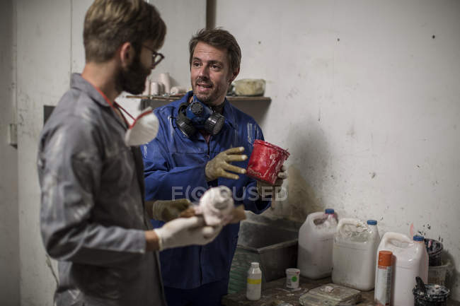Sculptors in artist studio discussing artistic equipment — Stock Photo