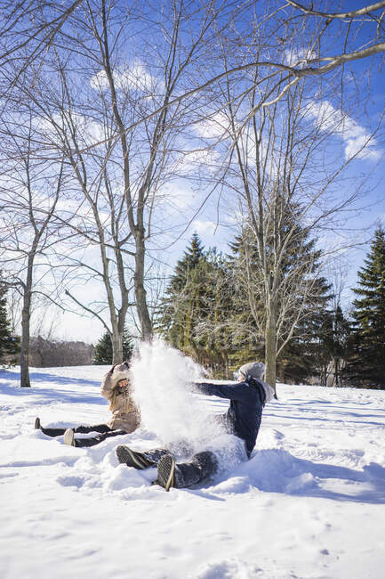 Dois amigos fazendo anjos de neve durante o inverno, Montreal, Quebec, Canadá — Fotografia de Stock