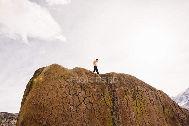 Человек на вершине скалы, Боулдерс, Бишоп, Калифорния, США — стоковое фото