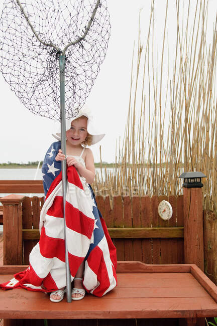 Девушка, завернутая в американский флаг сеткой — стоковое фото