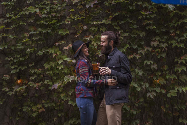 Молодая пара смеется в пивном саду вечером, Бруклин, Нью-Йорк, США — стоковое фото