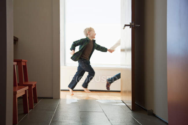 Dos niños corriendo por la puerta - foto de stock