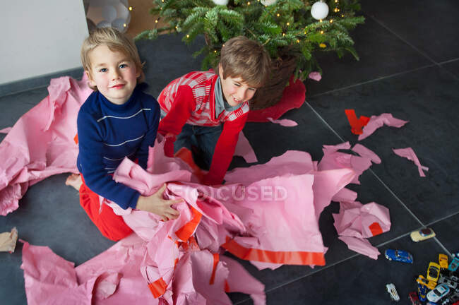 Zwei Jungen packen Weihnachtsgeschenke aus, Porträt — Stockfoto