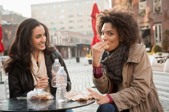 Женщины едят вместе в кафе на тротуаре — стоковое фото
